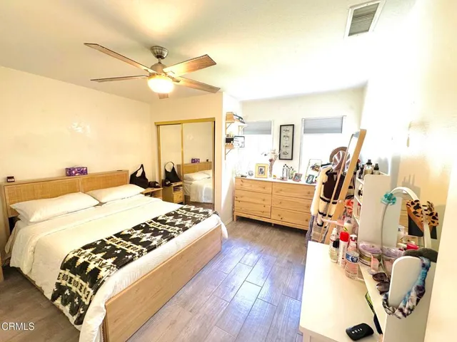 a bedroom with bed and wooden floor