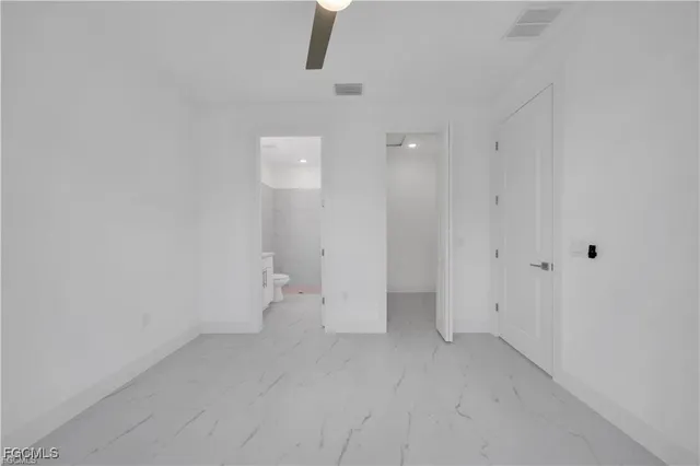 an empty room with windows and ceiling fan