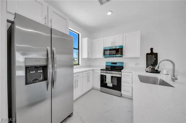 a kitchen with cabinets and stainless steel appliances