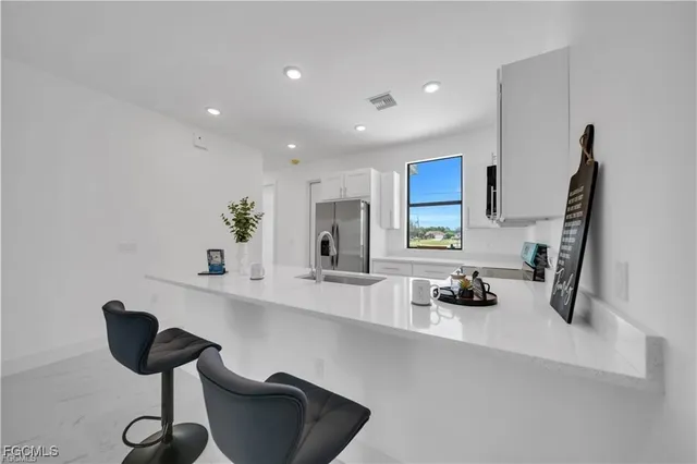 a kitchen with a sink and a stove top oven with wooden floor