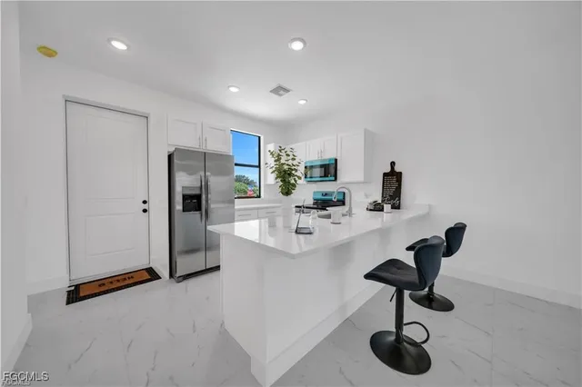 a kitchen with stainless steel appliances a refrigerator sink and microwave