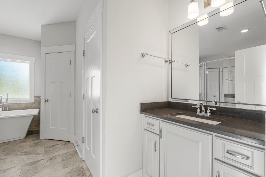 7044 Spring Walk Drive Columbus, GA 31904 - Photo 24 of 41 a bathroom with a granite countertop sink a large mirror and a bathtub