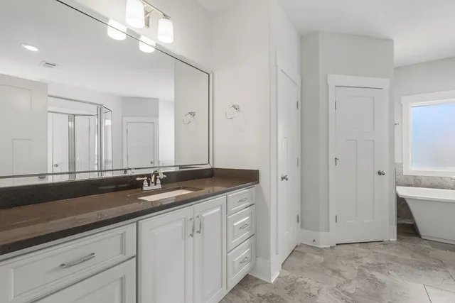 a spacious bathroom with a granite countertop sink a toilet and a mirror