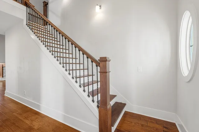 a view of staircase with wooden floor and white walls