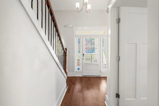 a view of a hallway with wooden floor and staircase