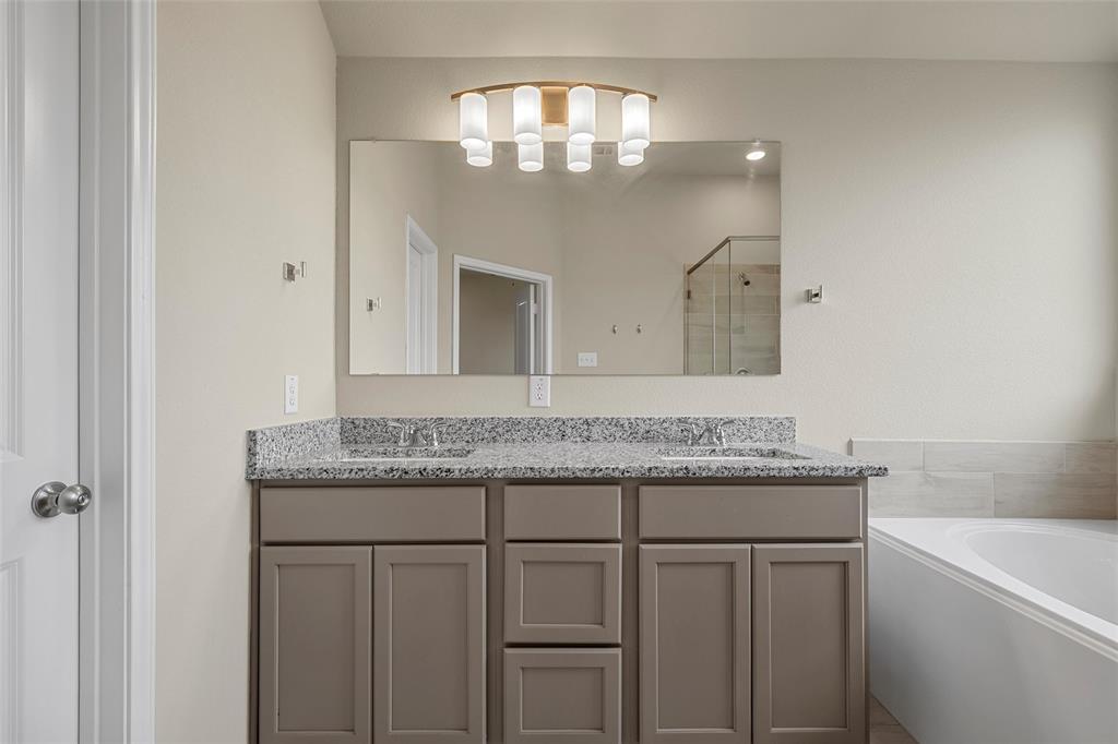 3205 Dottavio Road Lorena, TX 76655 - Photo 18 of 33 Bathroom featuring a dual vanity with a granite countertop, undermount sinks, and a framed mirror