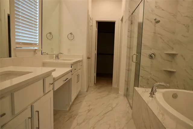 a spacious bathroom with a tub sink shower and mirror