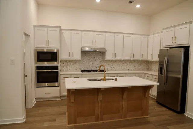 a kitchen with stainless steel appliances granite countertop a stove a refrigerator and a granite counter tops