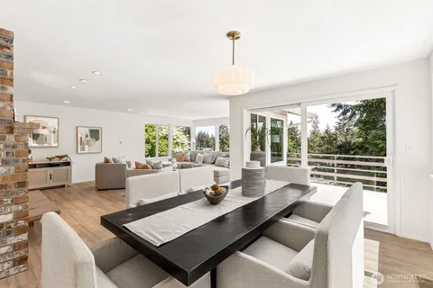 a kitchen with a table chairs wooden floor and a chandelier