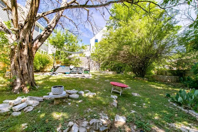 a view of yard with green space and trees