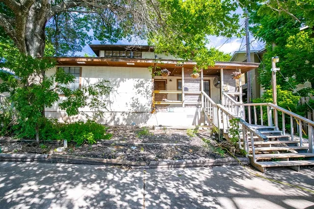 a view of a house with a small yard and floor to ceiling window