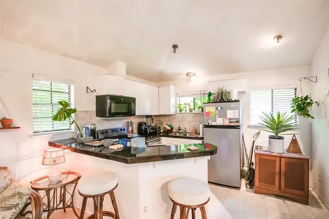 a kitchen with granite countertop a white table and chairs