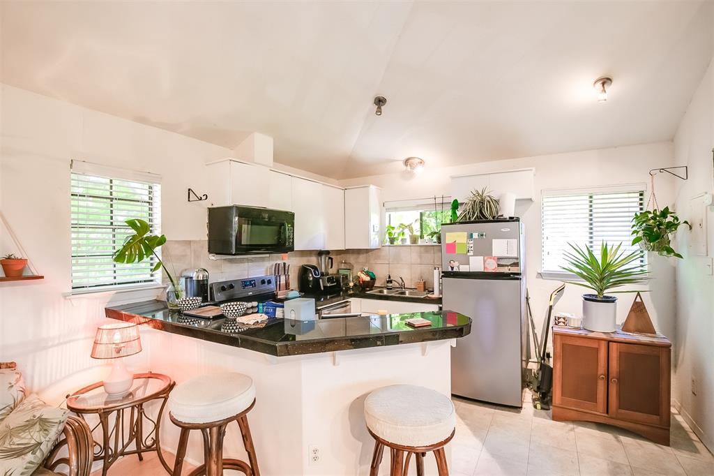 2400 Thornton Road, Unit B Austin, TX 78704 - Photo 5 of 13 a kitchen with granite countertop a white table and chairs