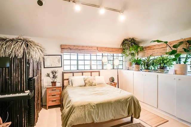 a bedroom with a bed and a large window with outer view