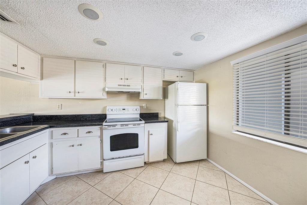 141 Lakeview Way, Unit 141 Oldsmar, FL 34677 - Photo 14 of 28 a kitchen with a white stove top oven and white stainless steel appliances