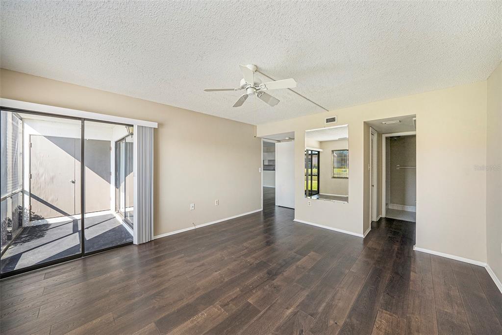141 Lakeview Way, Unit 141 Oldsmar, FL 34677 - Photo 18 of 28 an empty room with wooden floor mirror and windows