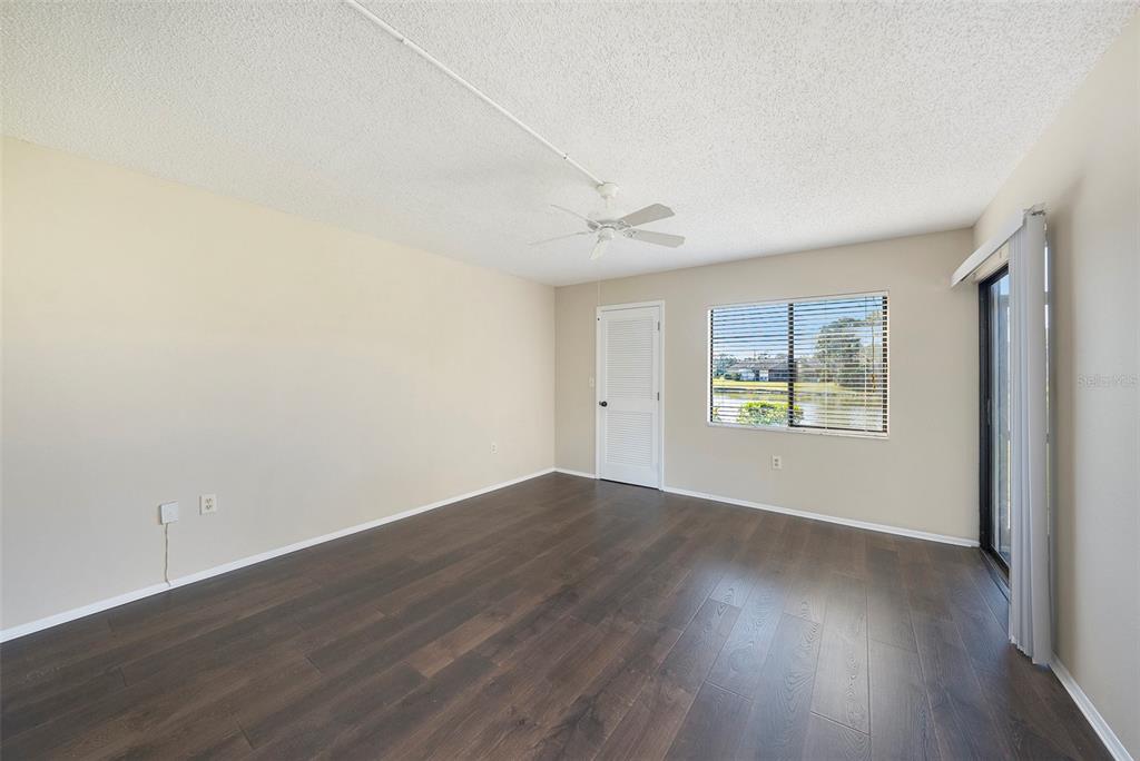 141 Lakeview Way, Unit 141 Oldsmar, FL 34677 - Photo 23 of 28 an empty room with wooden floor and windows