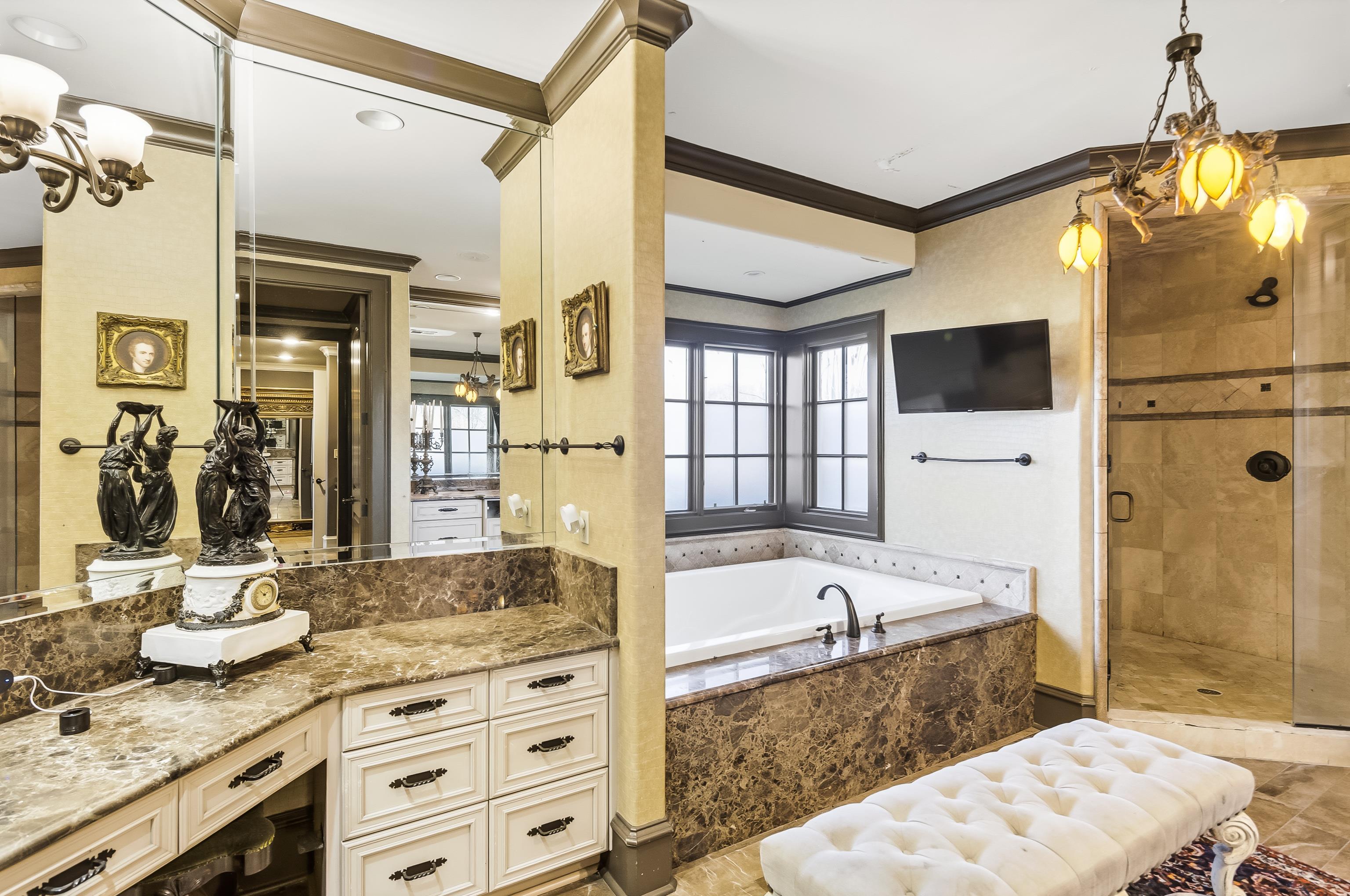 5110 Reynolds Road Collierville, TN 38017 - Photo 24 of 40 Bathroom featuring a garden tub, a shower stall, a chandelier, crown molding, and vanity