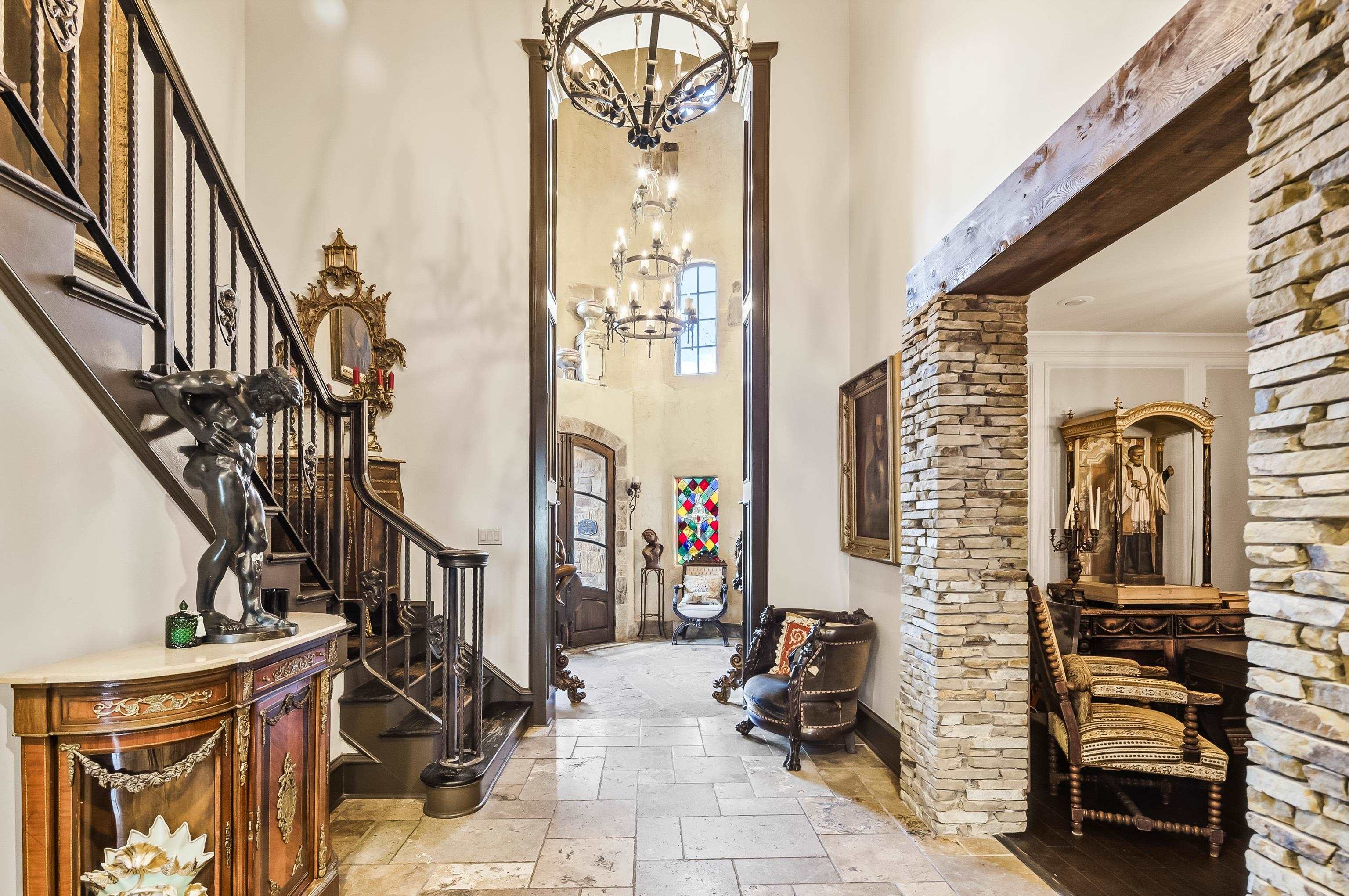 5110 Reynolds Road Collierville, TN 38017 - Photo 8 of 40 Entrance foyer featuring a towering ceiling, stone tile flooring, stairs, arched walkways, and a chandelier