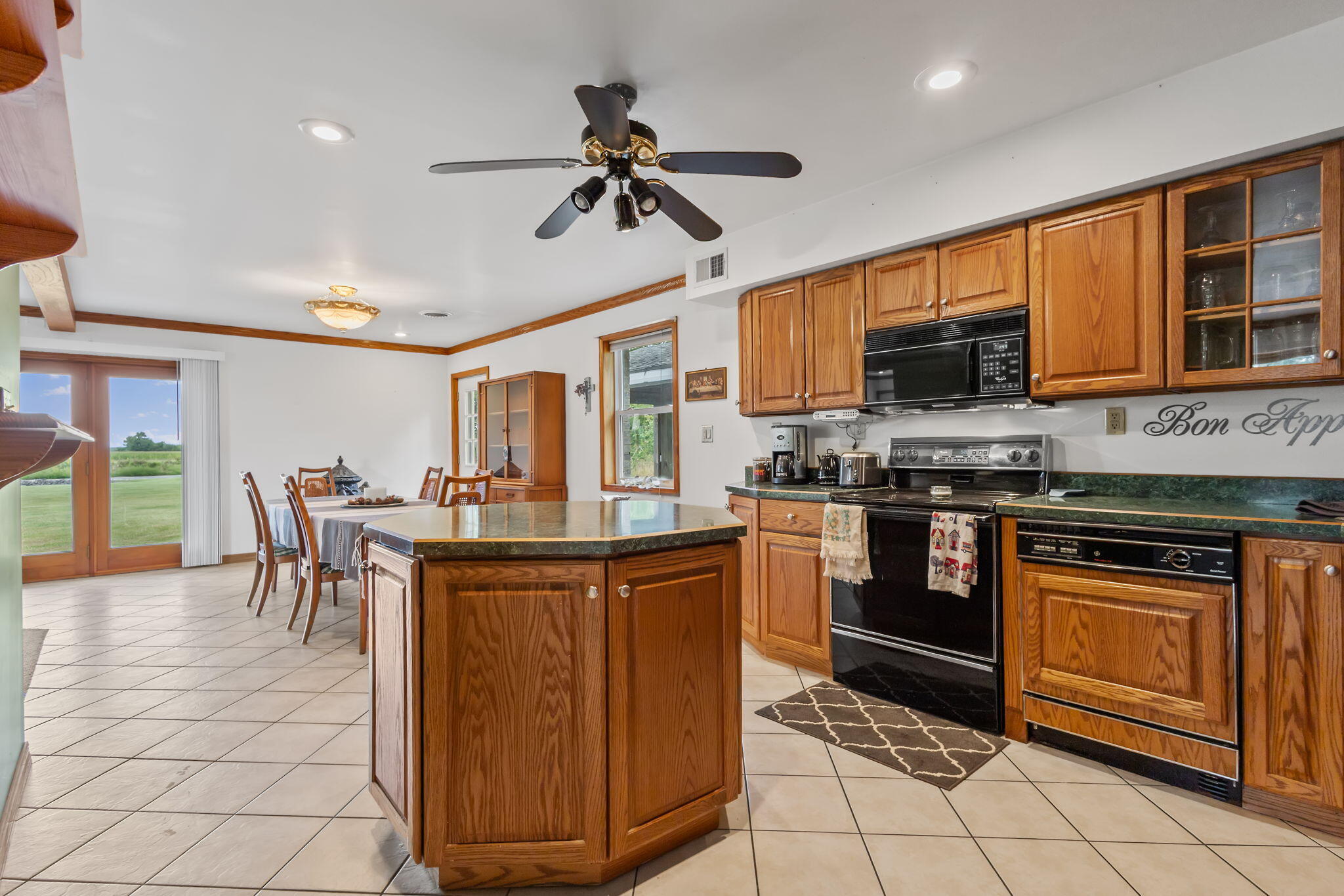 2549 East 1100 North Demotte, IN 46310 - Photo 13 of 74 a kitchen with stainless steel appliances granite countertop a stove top oven a sink a dining table and chairs with wooden floor