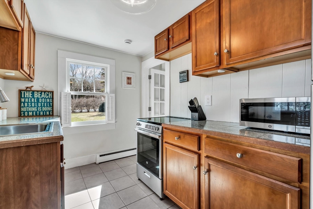 344 Main Street, Unit 5 Barnstable, MA 02632 - Photo 5 of 28 a kitchen with stainless steel appliances granite countertop a sink and a stove