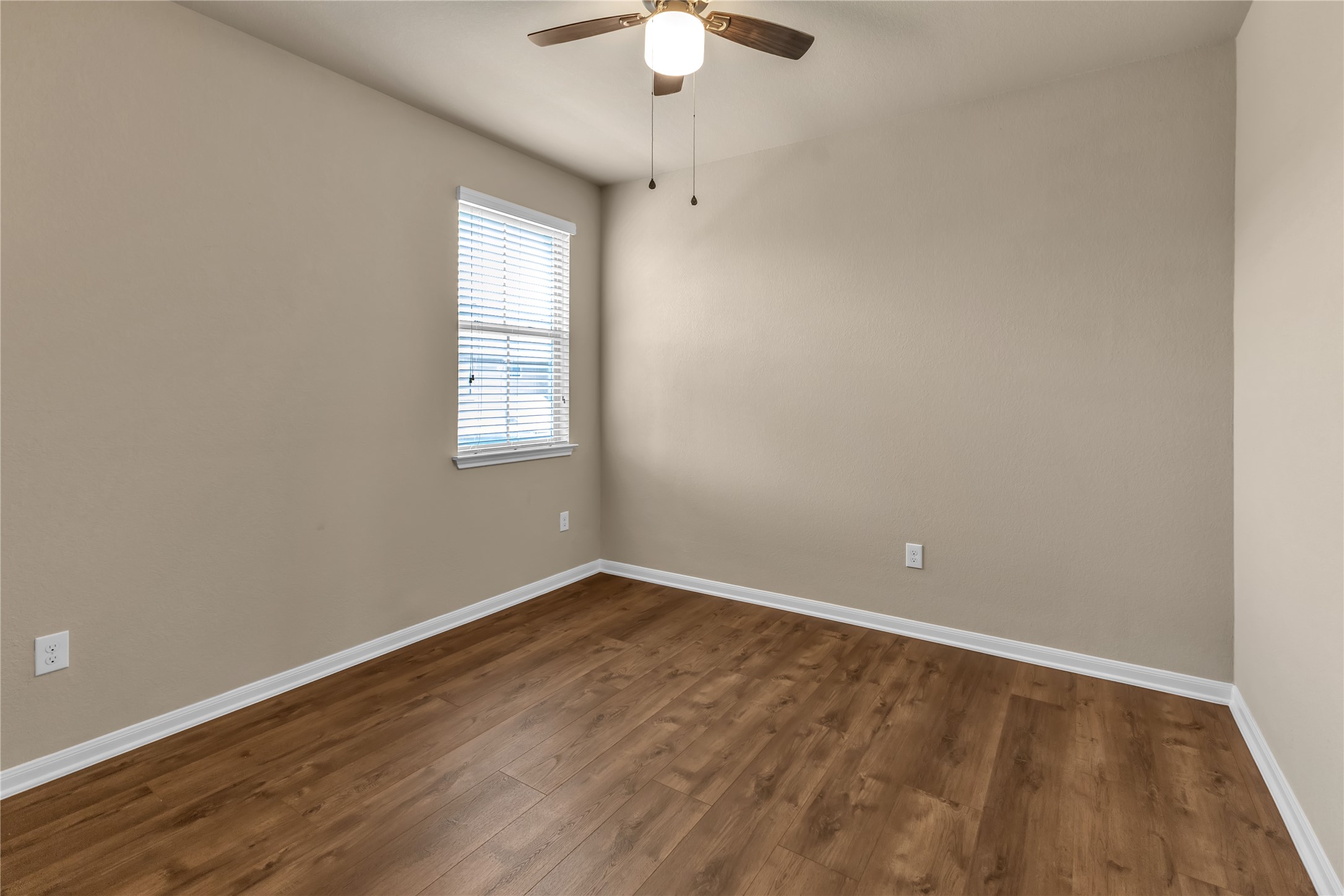2880 Donnell Drive, Unit 2003 Round Rock, TX 78664 - Photo 21 of 31 Room featuring wood-finish flooring, a window with blinds, a ceiling fan with light fixture, and neutral painted walls with white trim