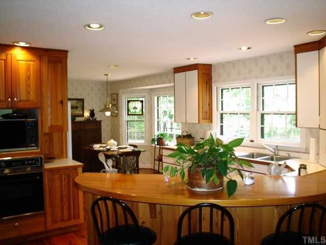 6808 Breezewood Road Raleigh, NC 27607 - Photo 12 of 12 The wife's dream kitchen with open floor plan to breakfast room, family room, living room and dining room. Updated kitchen adjoining breakfast room. Bay window allows view of back yard. Desk work area with book shelves and wine rack.