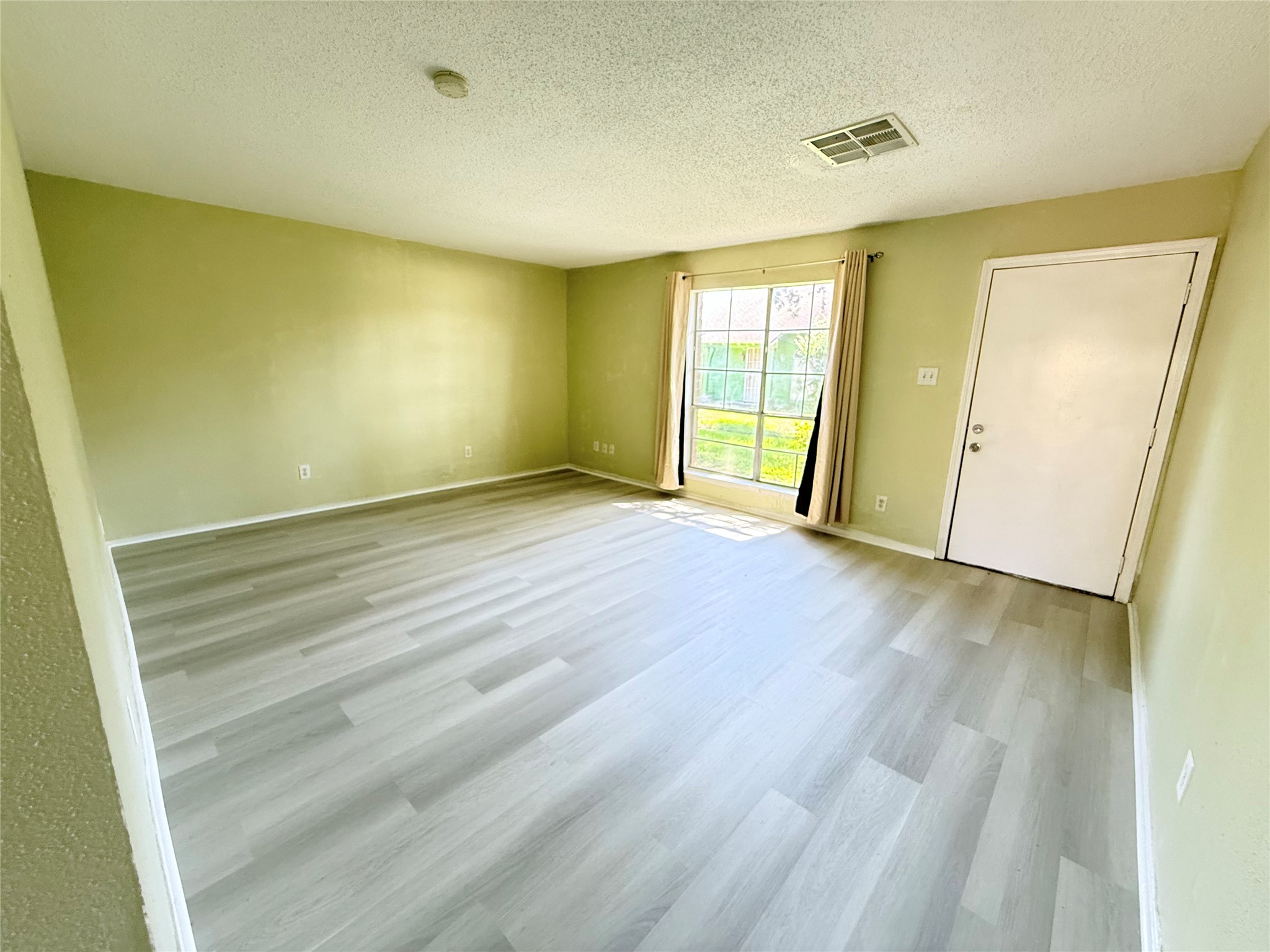 7789 Cook Road Houston, TX 77072 - Photo 10 of 18 a view of an empty room with wooden floor and a window