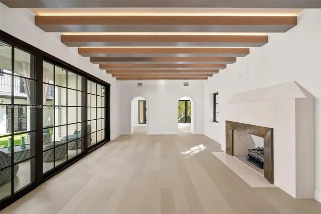 a view of a hallway with wooden floor and a living room