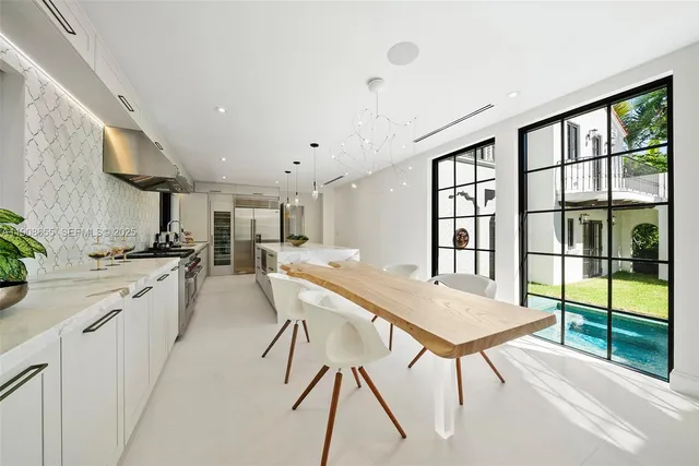 a view of an empty room with window and a kitchen