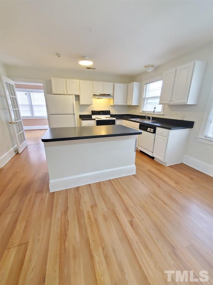 203 Jones Franklin Road Raleigh, NC 27606 - Photo 8 of 26 a living room with kitchen island granite countertop wooden floor and a sink