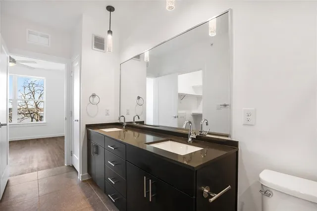 a spacious bathroom with a granite countertop sink a mirror and a bathtub