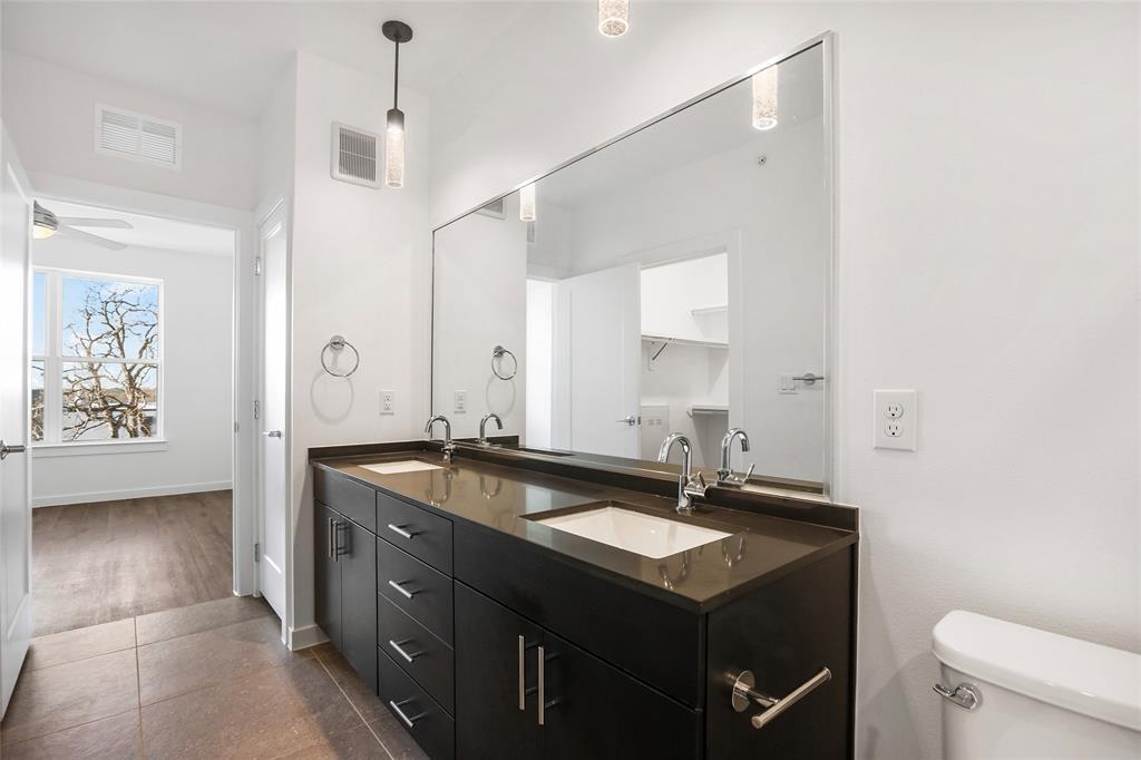 4801 Springdale Road Austin, TX 78723 - Photo 11 of 19 a spacious bathroom with a granite countertop sink a mirror and a bathtub