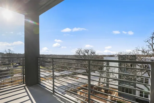 a view of a balcony with two chairs and a potted plant