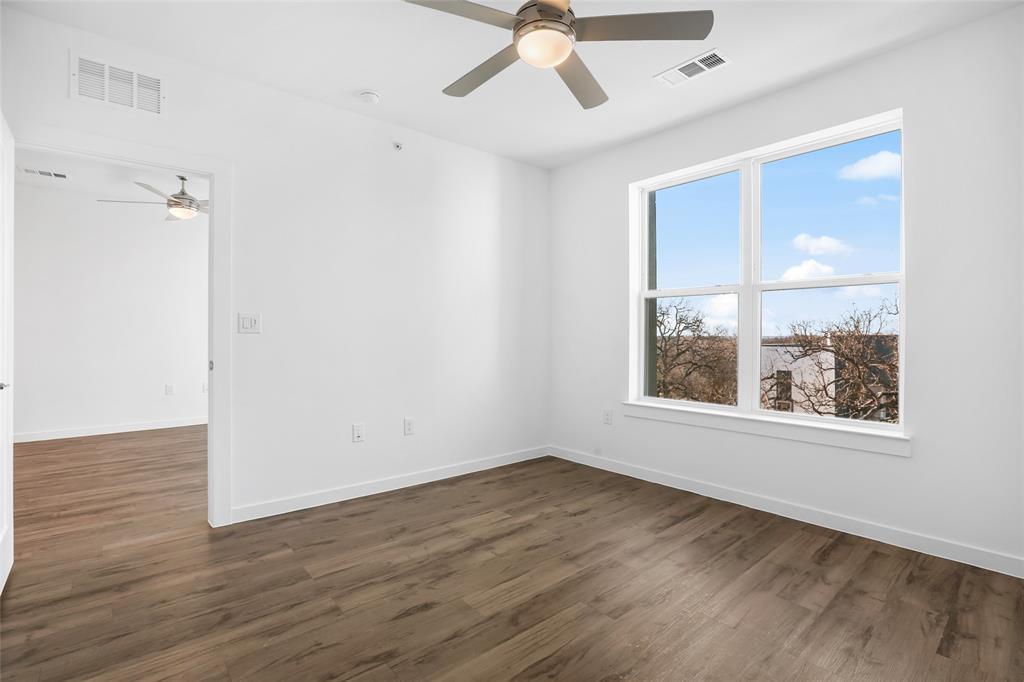4801 Springdale Road Austin, TX 78723 - Photo 9 of 19 an empty room with wooden floor fan and windows
