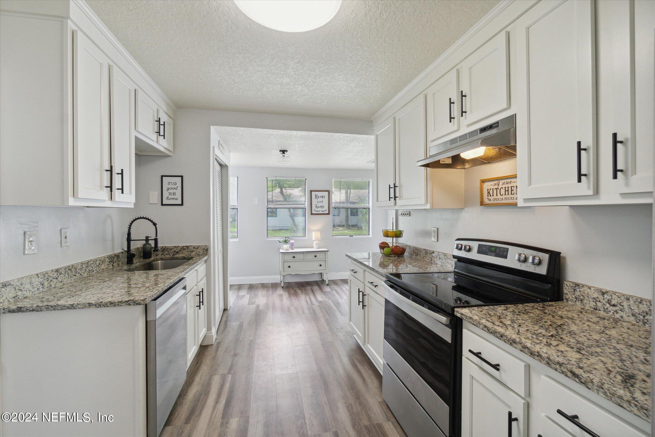 1262 Murray Drive Jacksonville, FL 32205 - Photo 16 of 42 a kitchen with a sink stove and cabinets