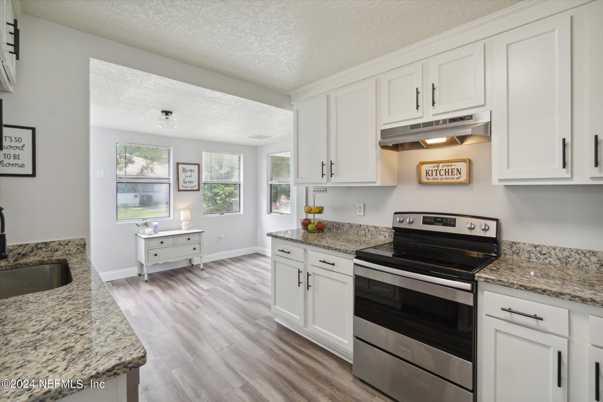 1262 Murray Drive Jacksonville, FL 32205 - Photo 17 of 42 a kitchen with granite countertop wooden floors appliances and cabinets