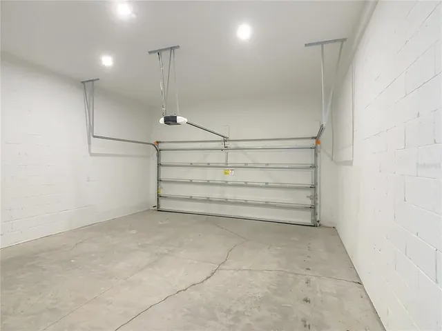 a view of an empty room with a chandelier fan