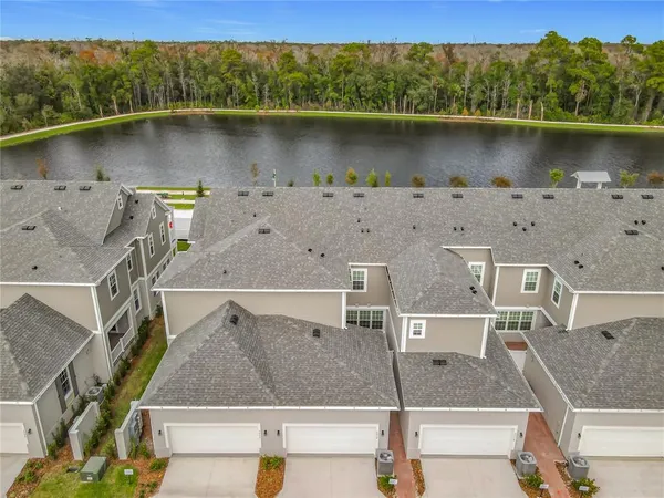 an aerial view of a residential houses with outdoor space and lake view