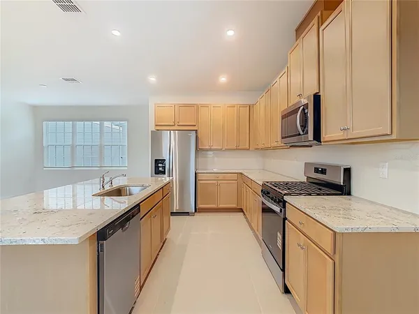 a kitchen with stainless steel appliances granite countertop a stove and a refrigerator
