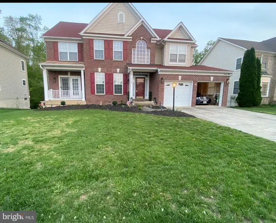 front view of a brick house with a yard