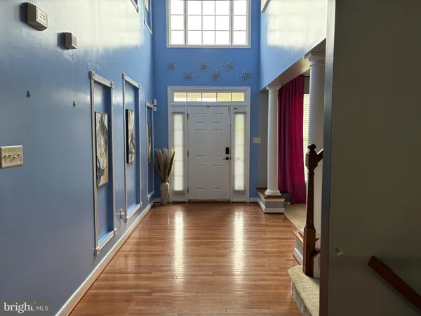 a view of hallway with stairs and wooden floor