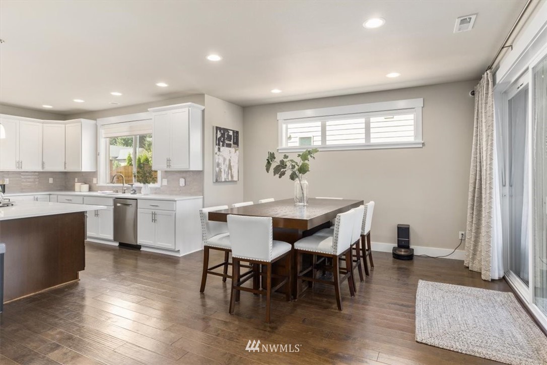1441 242nd Place Southeast Bothell, WA 98021 - Photo 18 of 40 a kitchen with a dining table chairs cabinets wooden floor and appliances