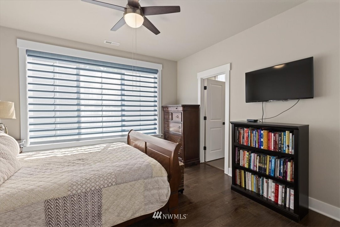 1441 242nd Place Southeast Bothell, WA 98021 - Photo 21 of 40 a bedroom with a bed a flat screen tv and a book shelf