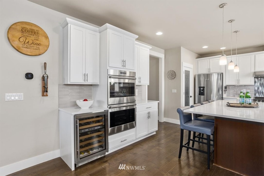 1441 242nd Place Southeast Bothell, WA 98021 - Photo 8 of 40 a kitchen with stainless steel appliances a stove a refrigerator a white table and chairs
