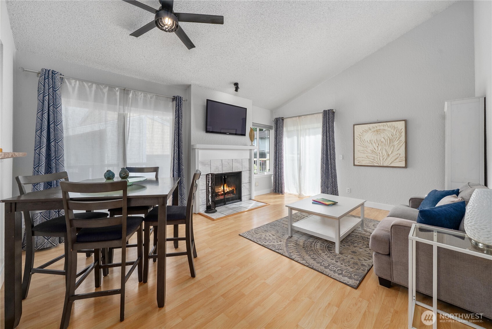 14401 Southeast Petrovitsky Road, Unit G204 Renton, WA 98058 - Photo 2 of 29 a living room with furniture a fireplace and a flat screen tv