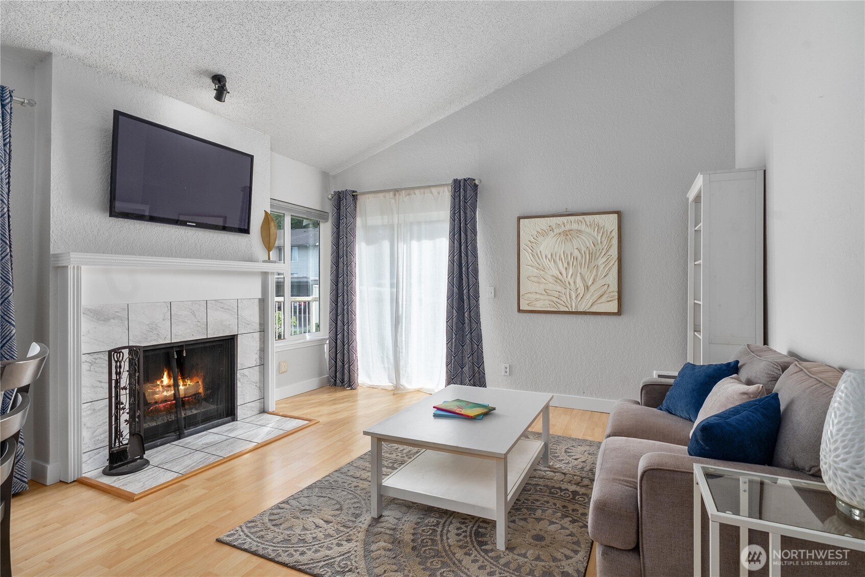 14401 Southeast Petrovitsky Road, Unit G204 Renton, WA 98058 - Photo 3 of 29 a living room with furniture a flat screen tv and a fireplace