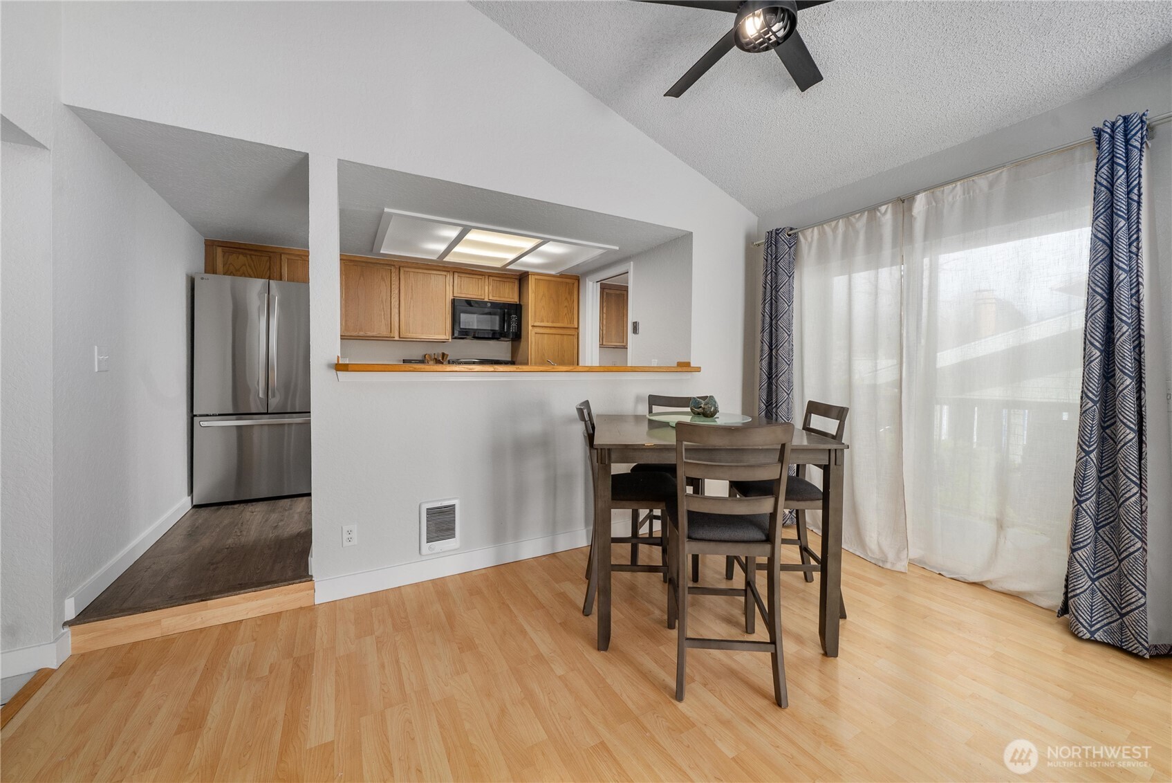 14401 Southeast Petrovitsky Road, Unit G204 Renton, WA 98058 - Photo 6 of 29 a kitchen with stainless steel appliances wooden floor and dining table
