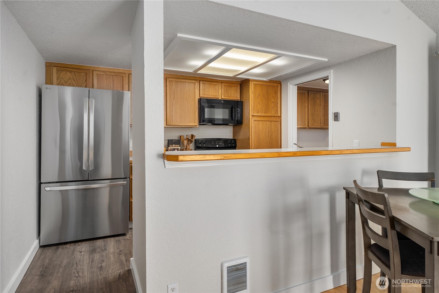 14401 Southeast Petrovitsky Road, Unit G204 Renton, WA 98058 - Photo 7 of 29 a kitchen with stainless steel appliances a refrigerator and a stove top oven