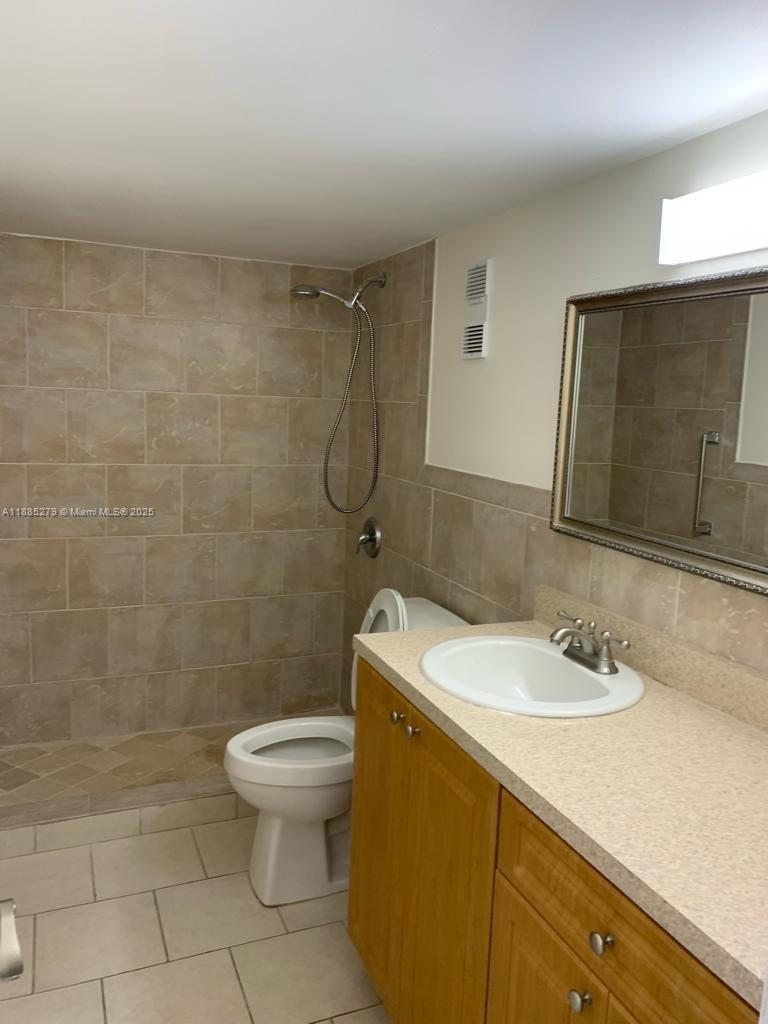 1555 West 44th Place, Unit 234 Hialeah, FL 33012 - Photo 16 of 36 a bathroom with a sink a toilet and a mirror